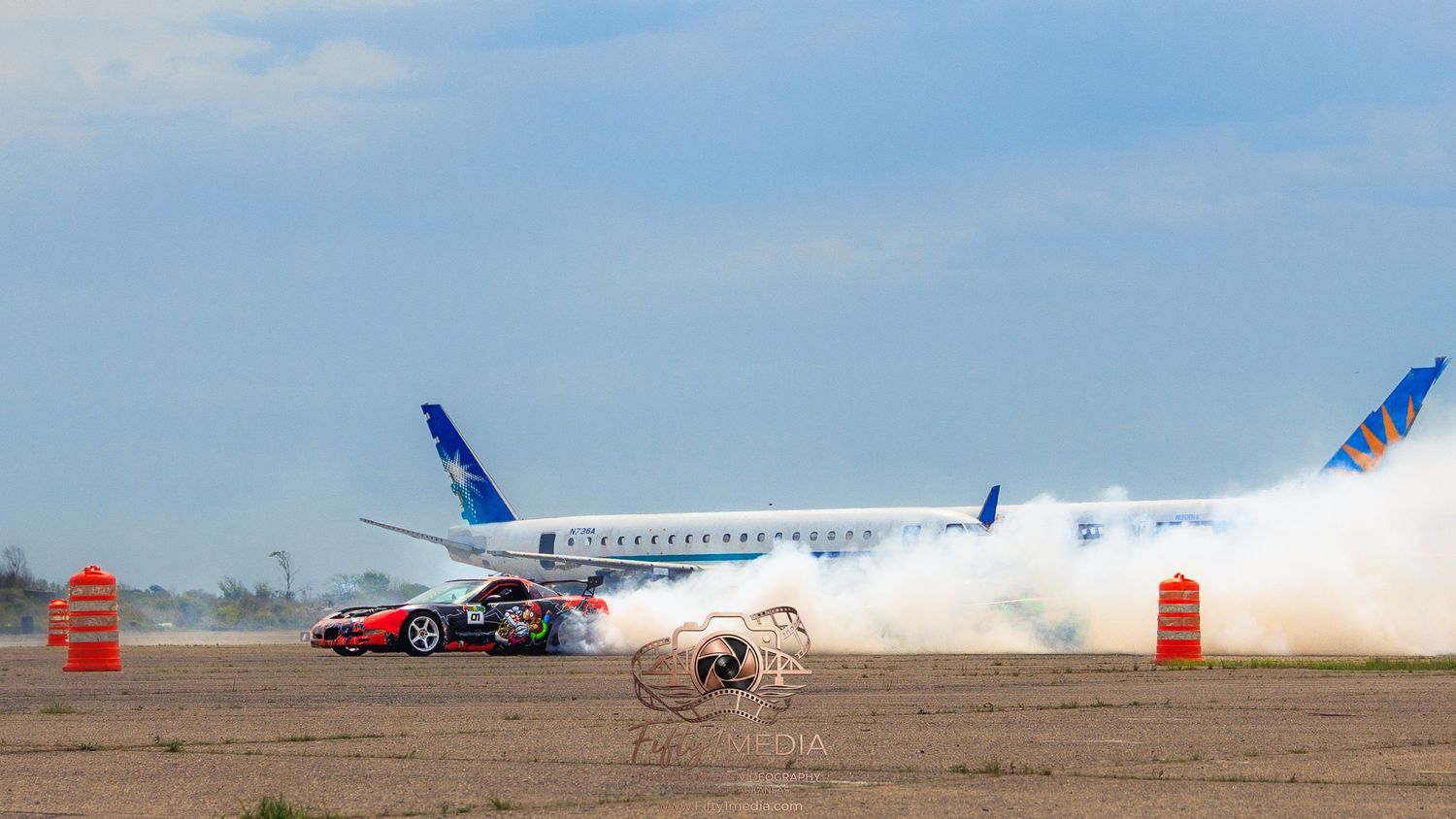 Red sports car enveloped in a massive cloud of white tire smoke during an Arkansas drift event.