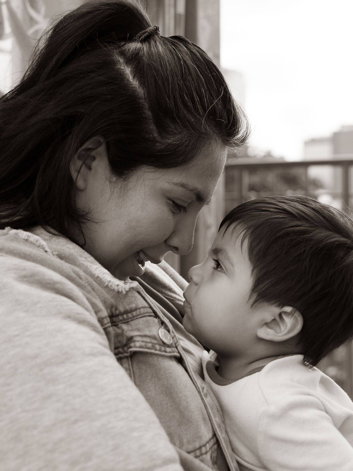 Black and white lifestyle portrait of a mother holding her toddler at the River Market in Little Rock, Arkansas.