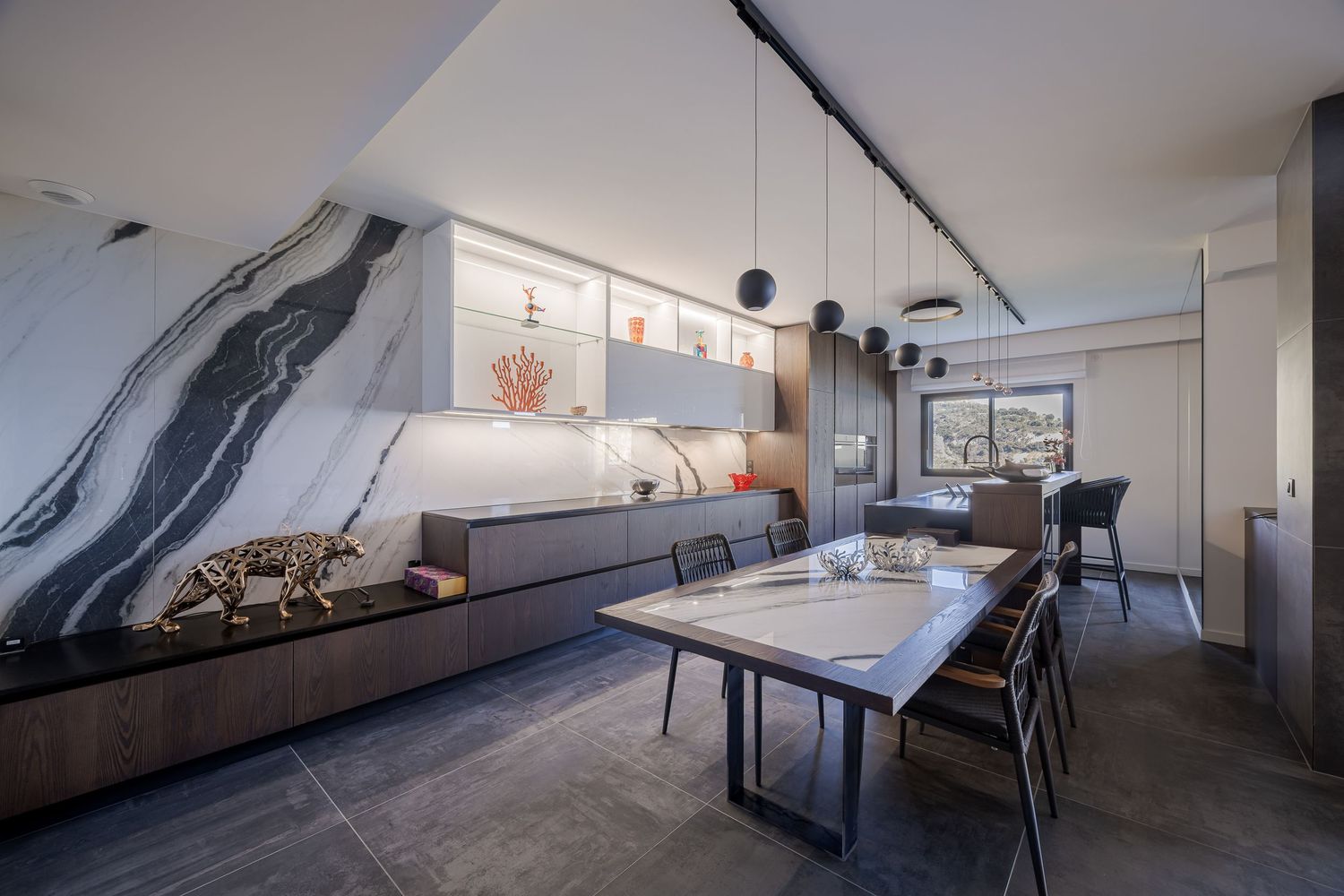 Design de cuisine-salle à manger moderne avec mur en marbre veiné noir et blanc, reportage d'architecture intérieure.