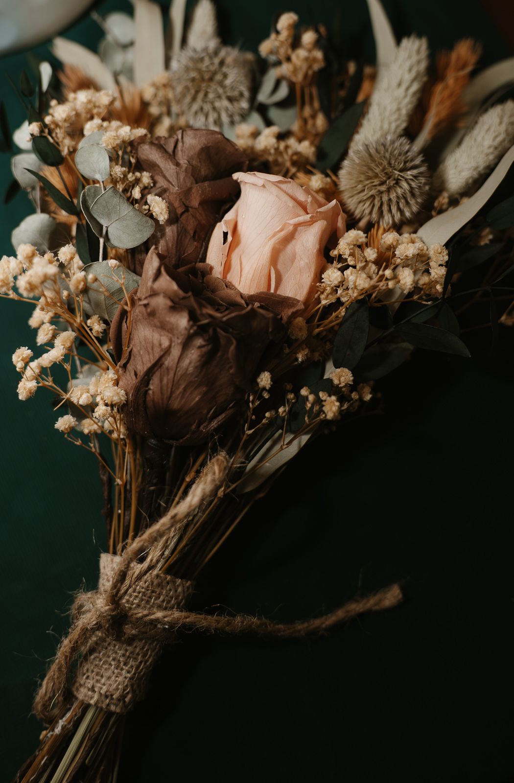 Rustic dried floral bouquet with a peach rose, baby's breath, and euclidean tied with burlap.