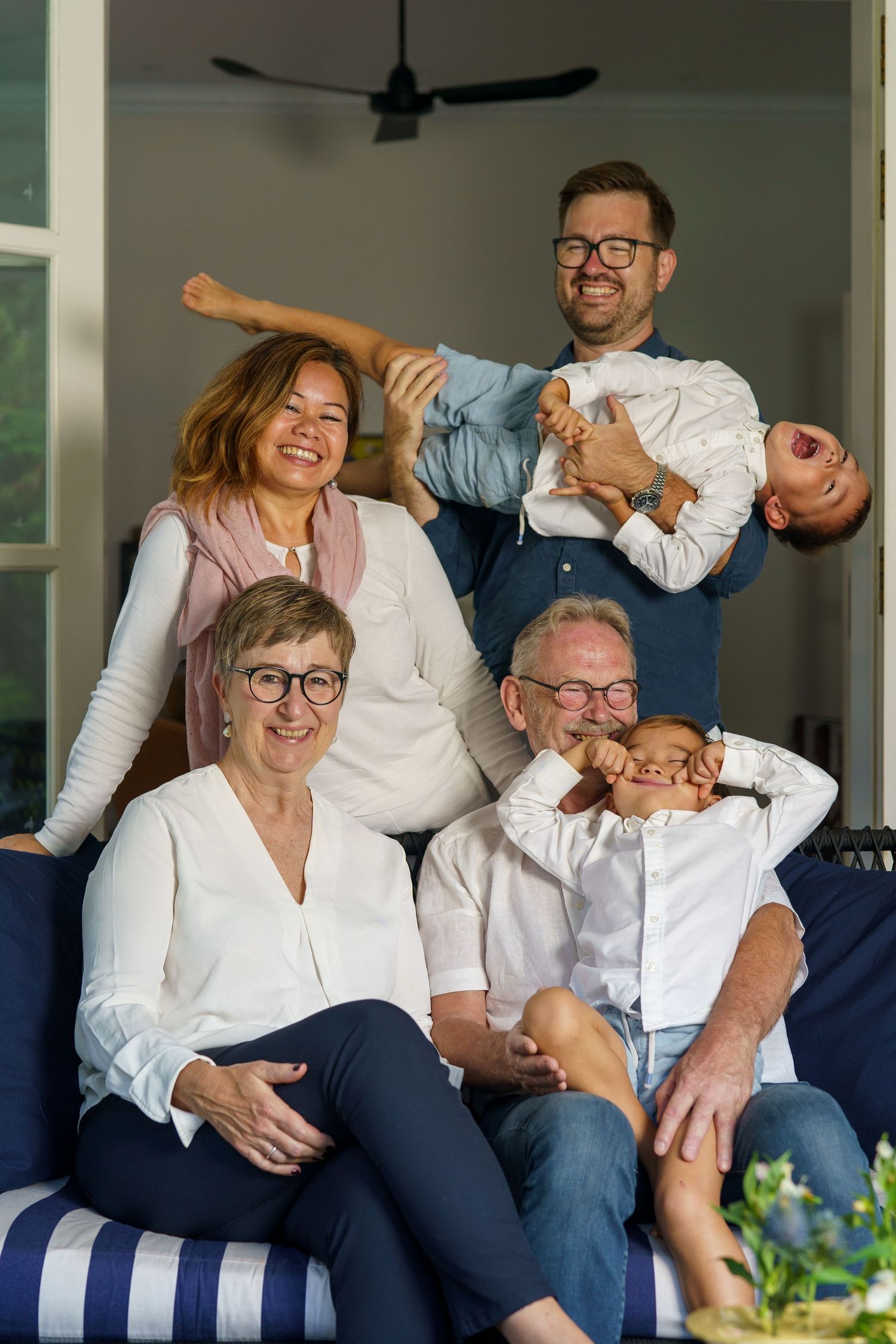A joyful family of six, 3 generations together, enjoying a fun and relaxed portrait session in Saigon.