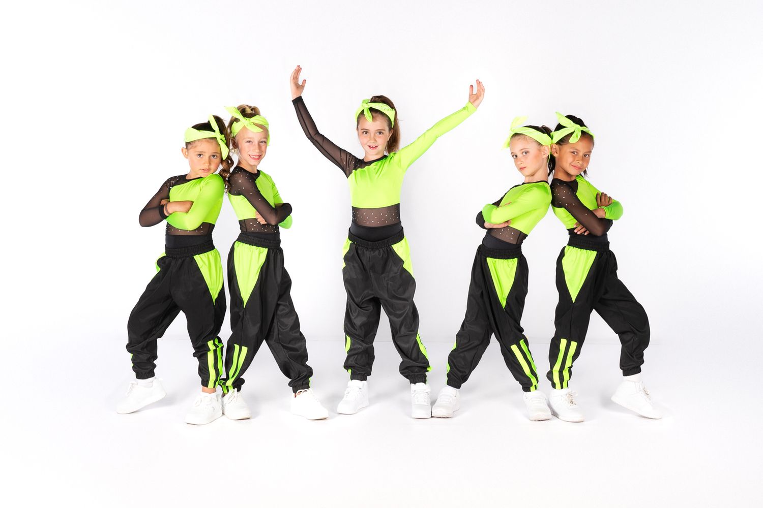Dance team performing energetic routine in black and neon green hip-hop outfits.