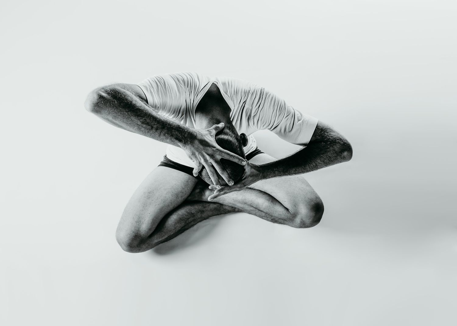 Black and white photo capturing dancer's graceful folded position.