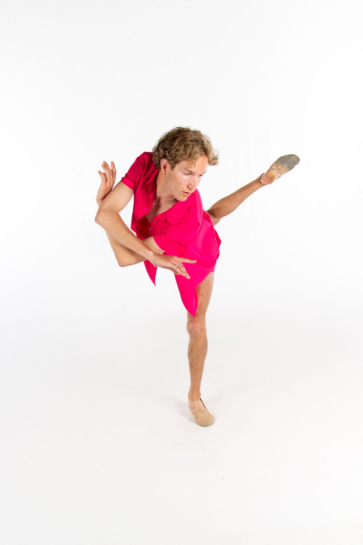 Modern dancer in vibrant red costume executing dynamic pose with extended limbs.