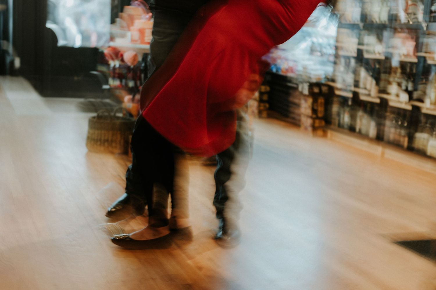 A red dress twirls gracefully in motion creating a dynamic spinning effect against a dark background.