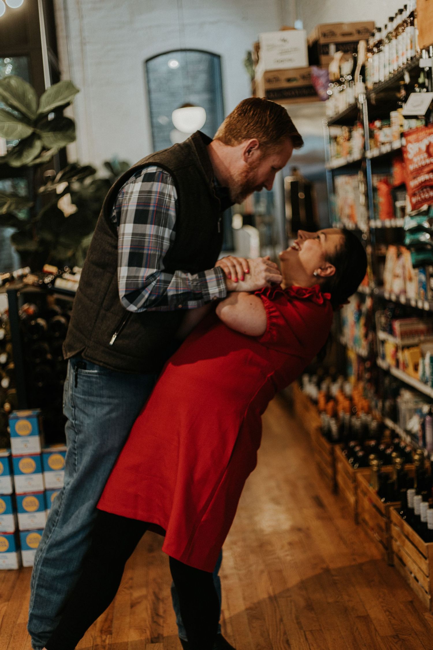 A couple shares a romantic moment while shopping in a grocery store aisle.