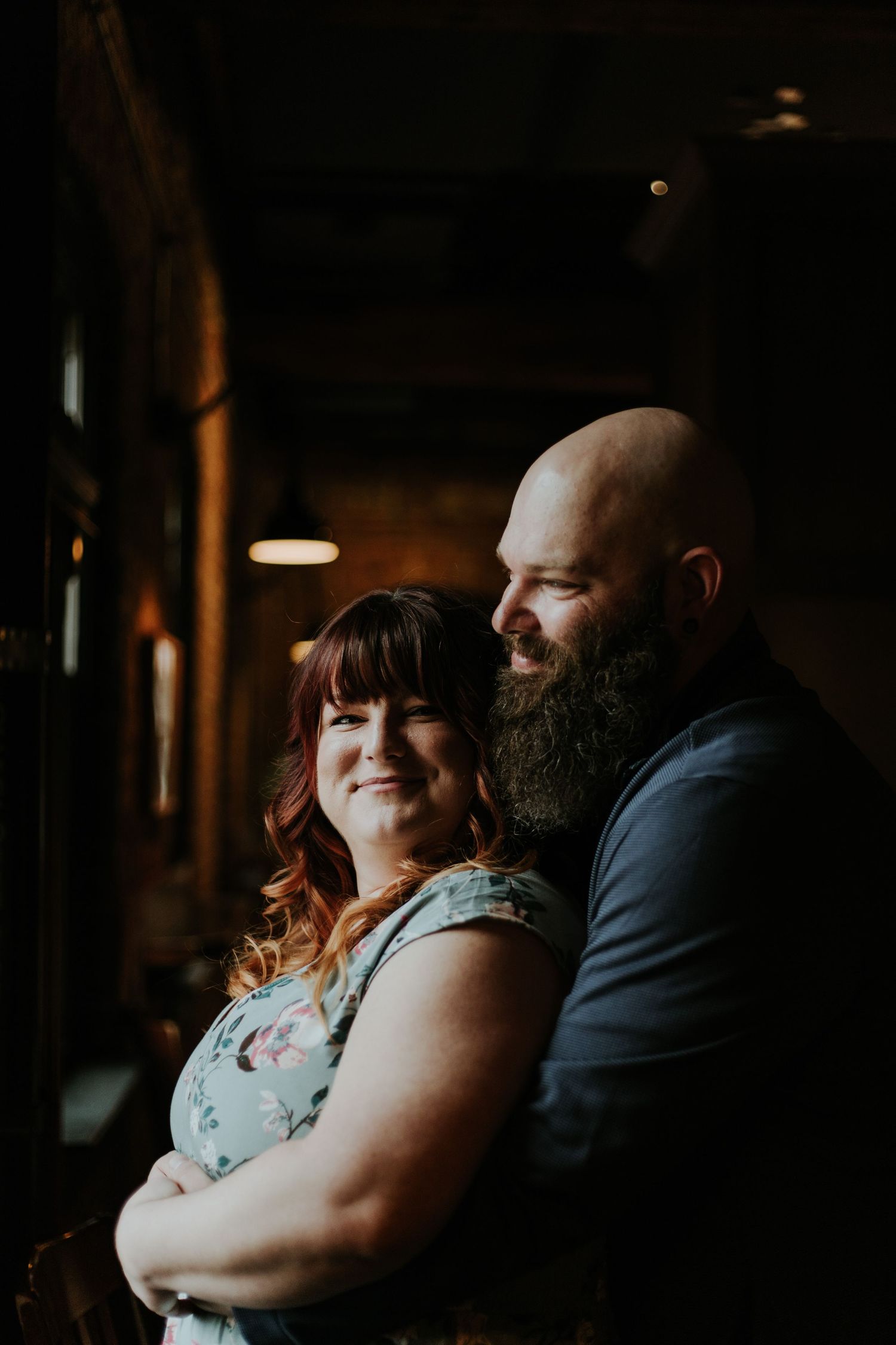 Intimate wedding photography series showing couple embracing in moody low-light setting with romantic atmosphere.