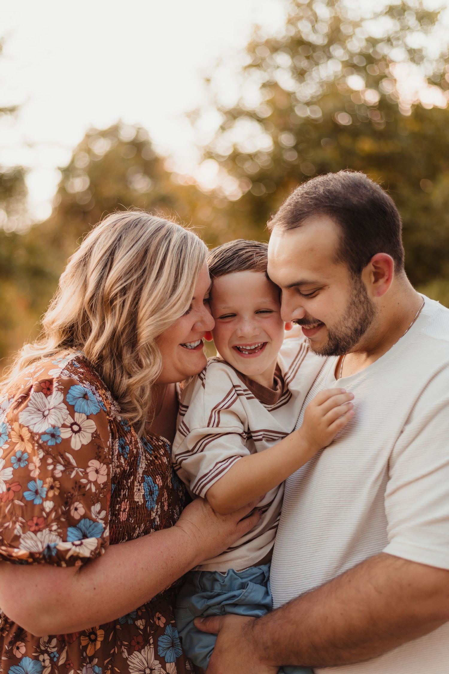 A family shares an intimate moment of laughter during a sunset portrait session.