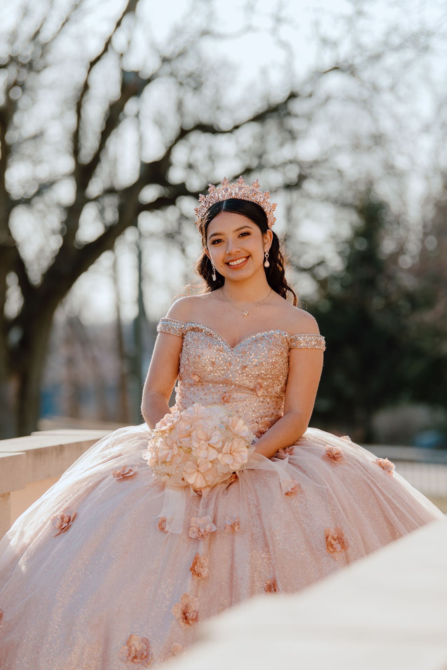 Pink ball gown with floral appliques shown in multiple angles outdoors.