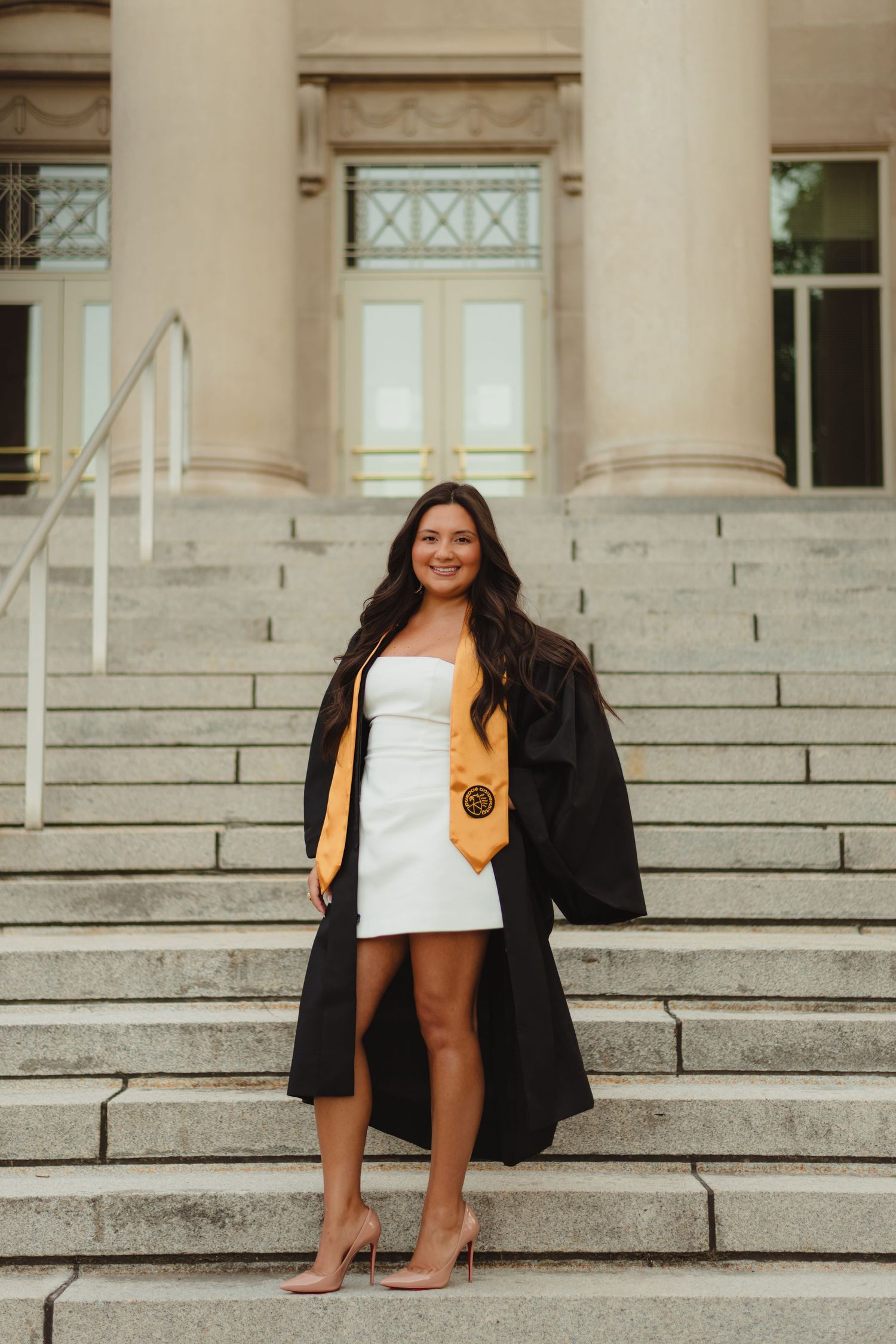 A graduation photo collage showing a graduate in cap and gown sitting on stone steps of a building  at Purdue Campus in West Lafayette, IN