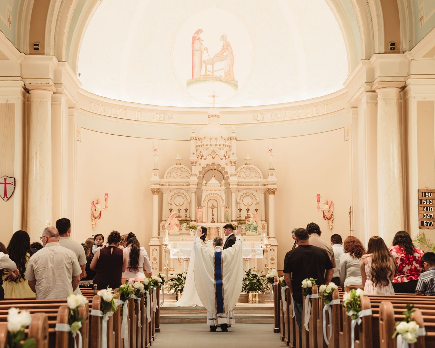 A couple exchanges vows at a Catholic church altar in Lafayette, Indiana.