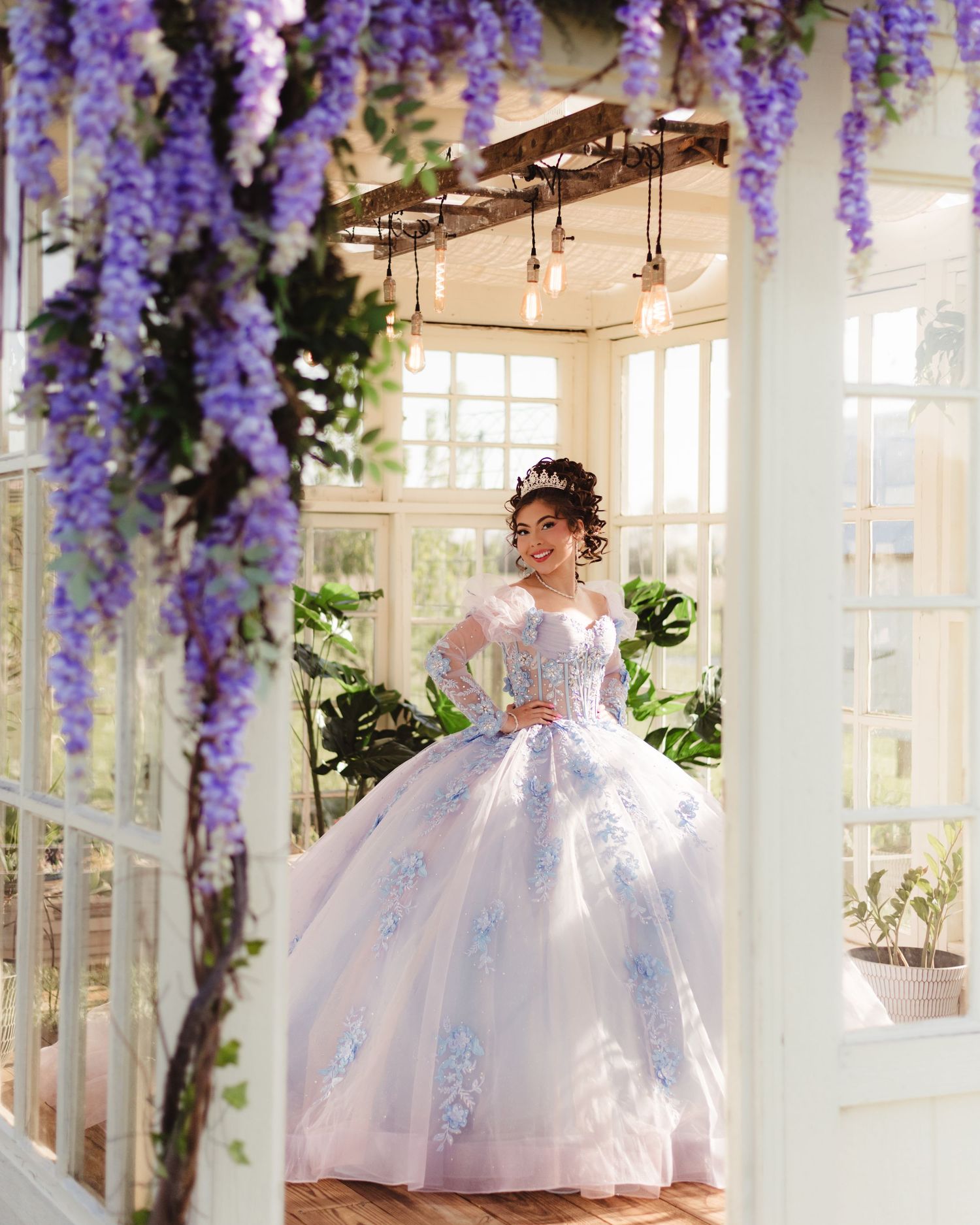 Bridgeton quinceañera ball gown with florals in a sunlit greenhouse adorned with wisteria in Lafayette, Indiana.