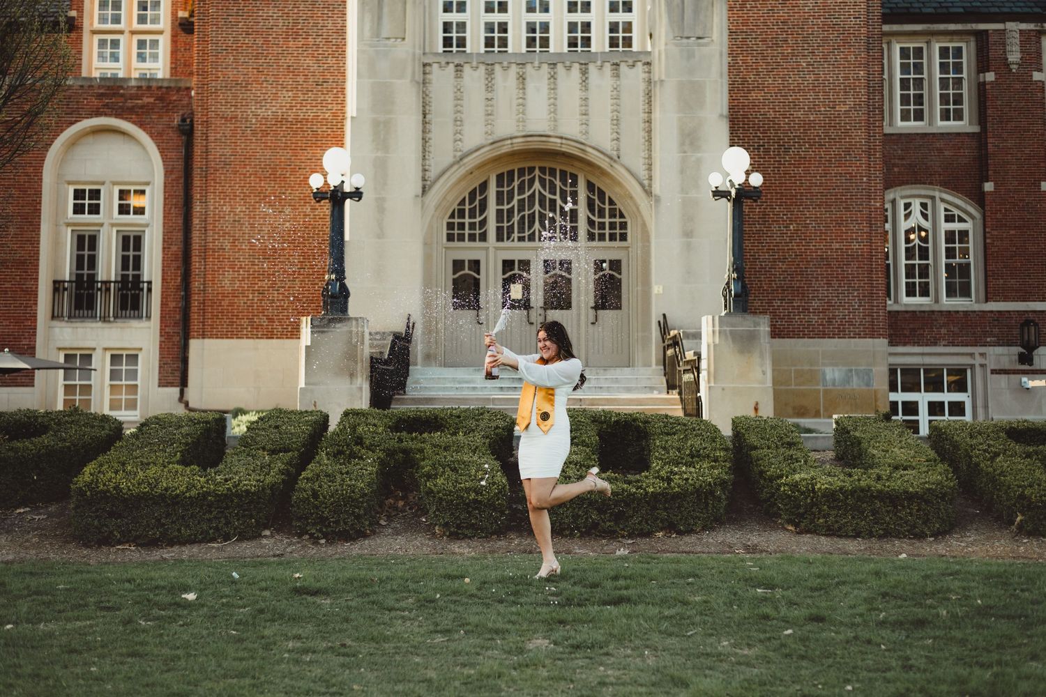 Purdue Graduate popping bottle of champagne  at Purdue Campus in West Lafayette, IN.