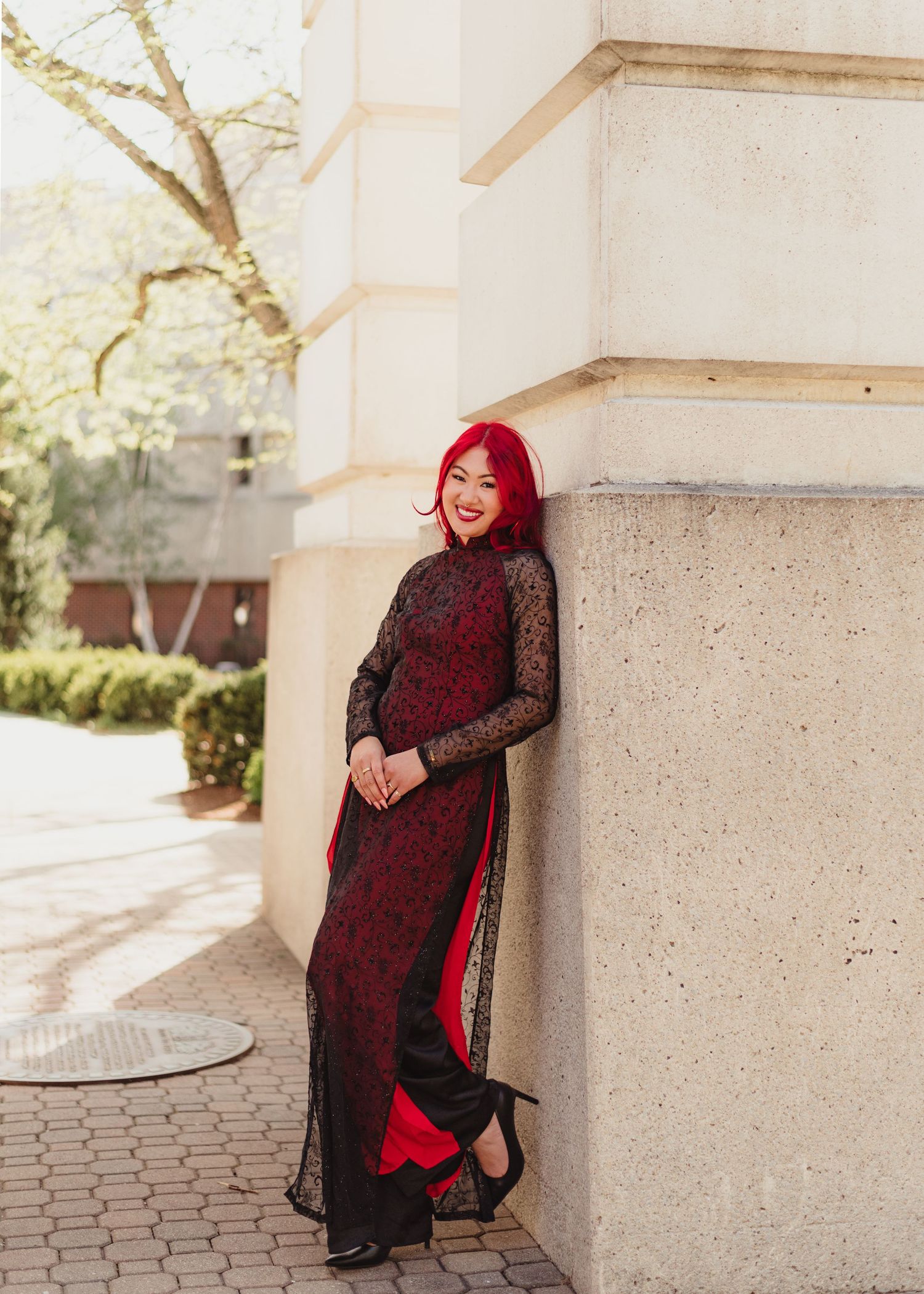A series of fashion portraits showing a red and black lace dress styled with a hijab against a light stone wall backdrop at Purdue.