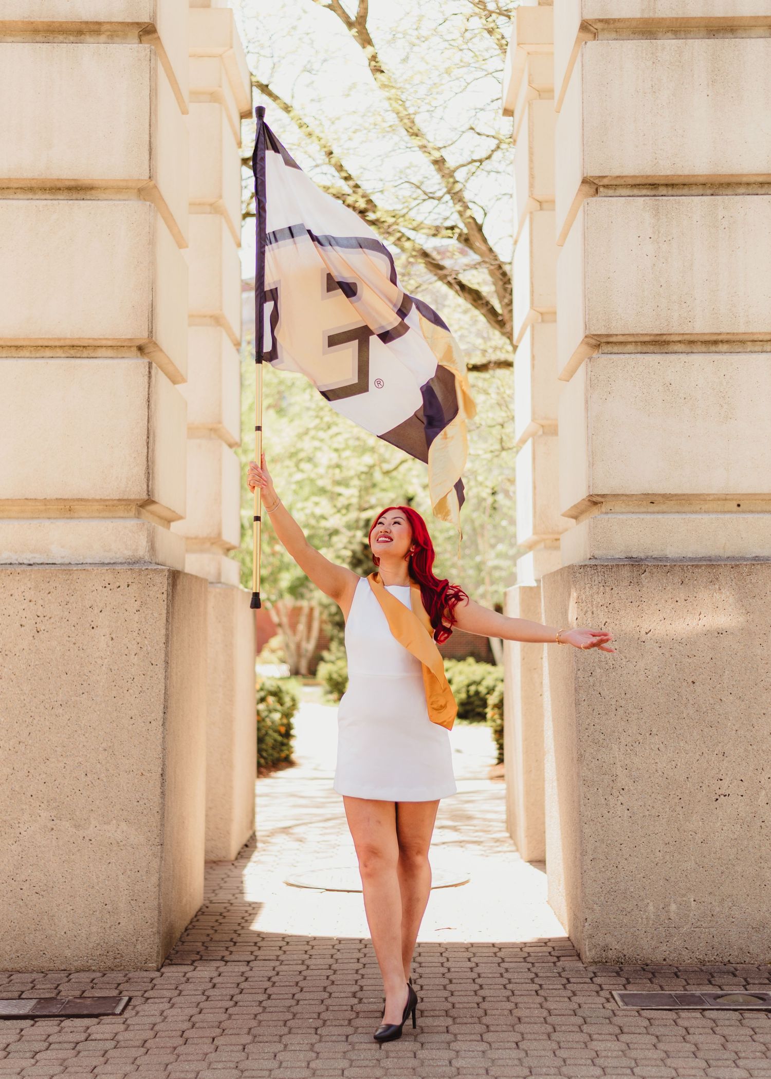 A sequence of joyful graduation photos captured under architectural columns with confetti tossing in the air  at Purdue Campus in Indiana.
