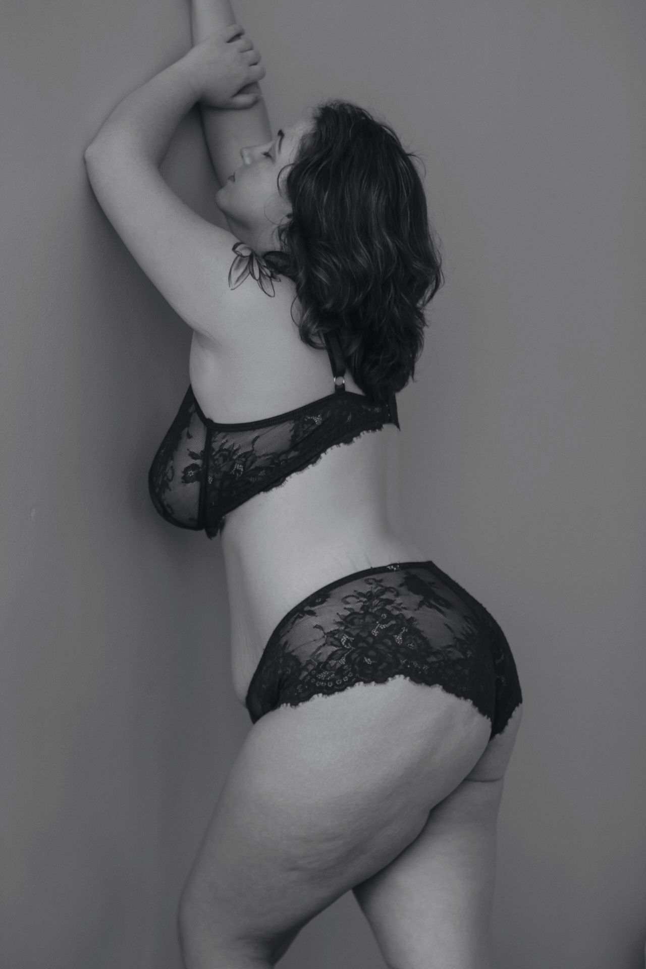 Intimate black and white portrait series showcasing curves and natural beauty in dark lingerie.