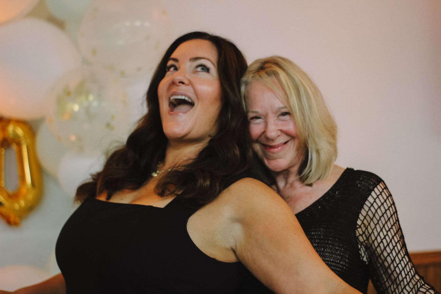 Group of friends sharing laughs and hugs during a celebration.