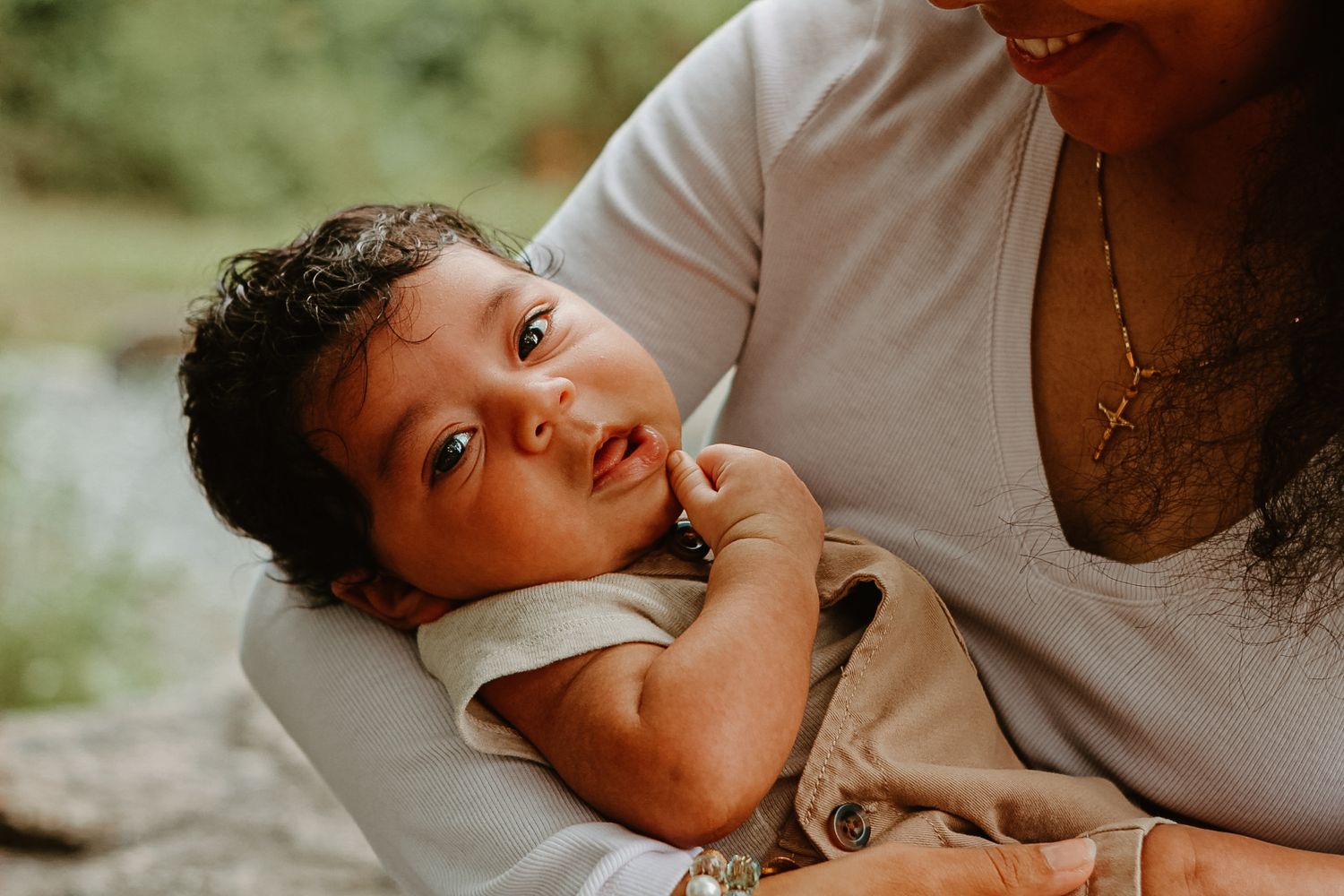 Baby laying on soft surface with joyful expressions in natural lighting.