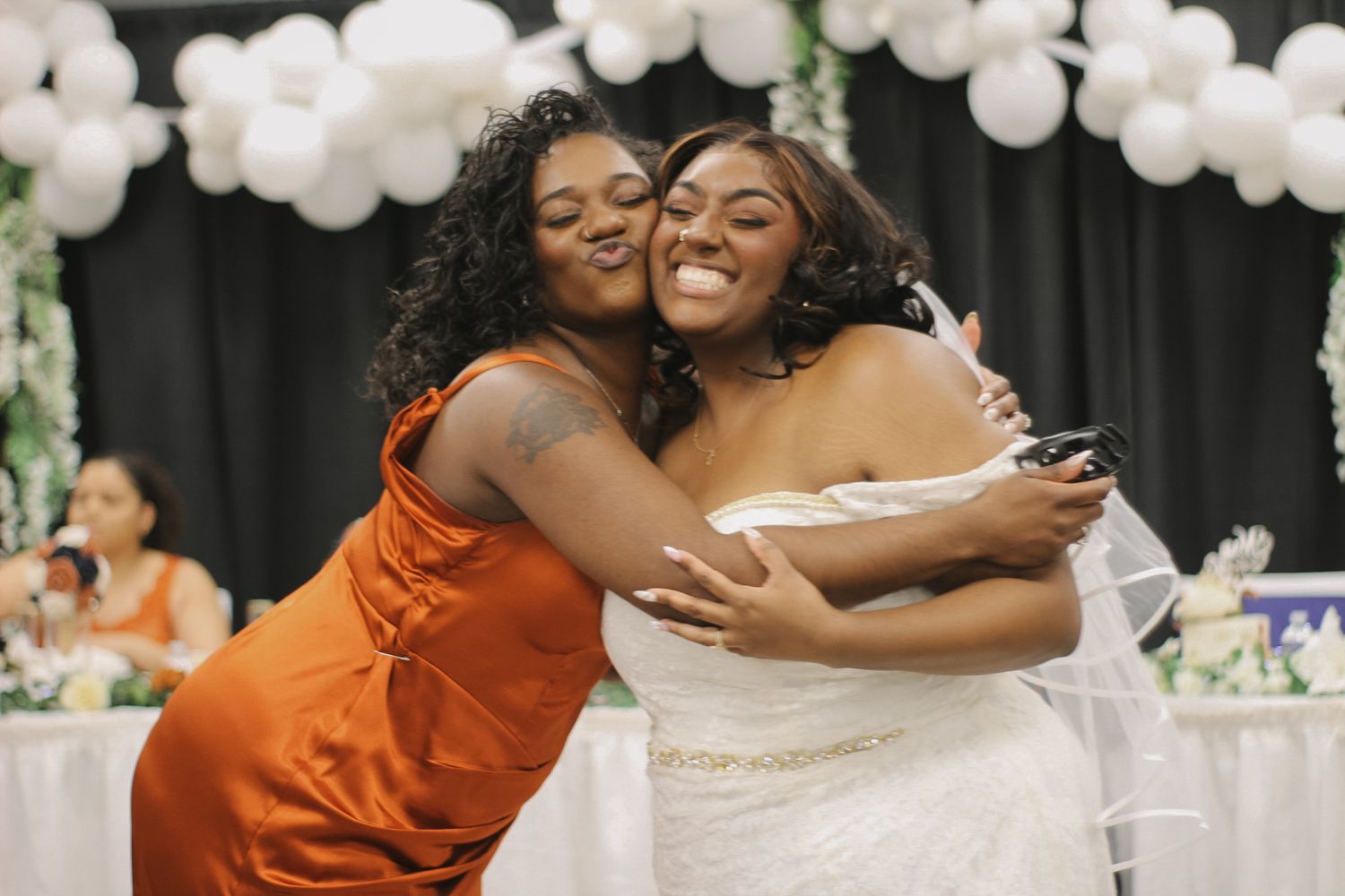 A heartwarming embrace shared during wedding celebrations with balloon decorations.