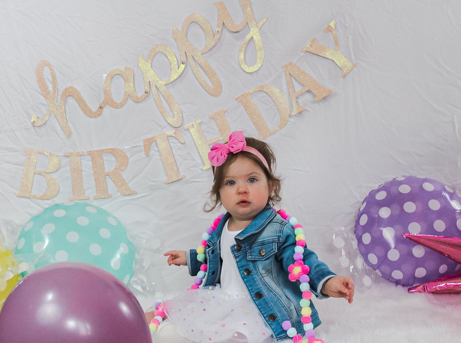 Birthday party setup with pastel decorations and balloons against a light background.