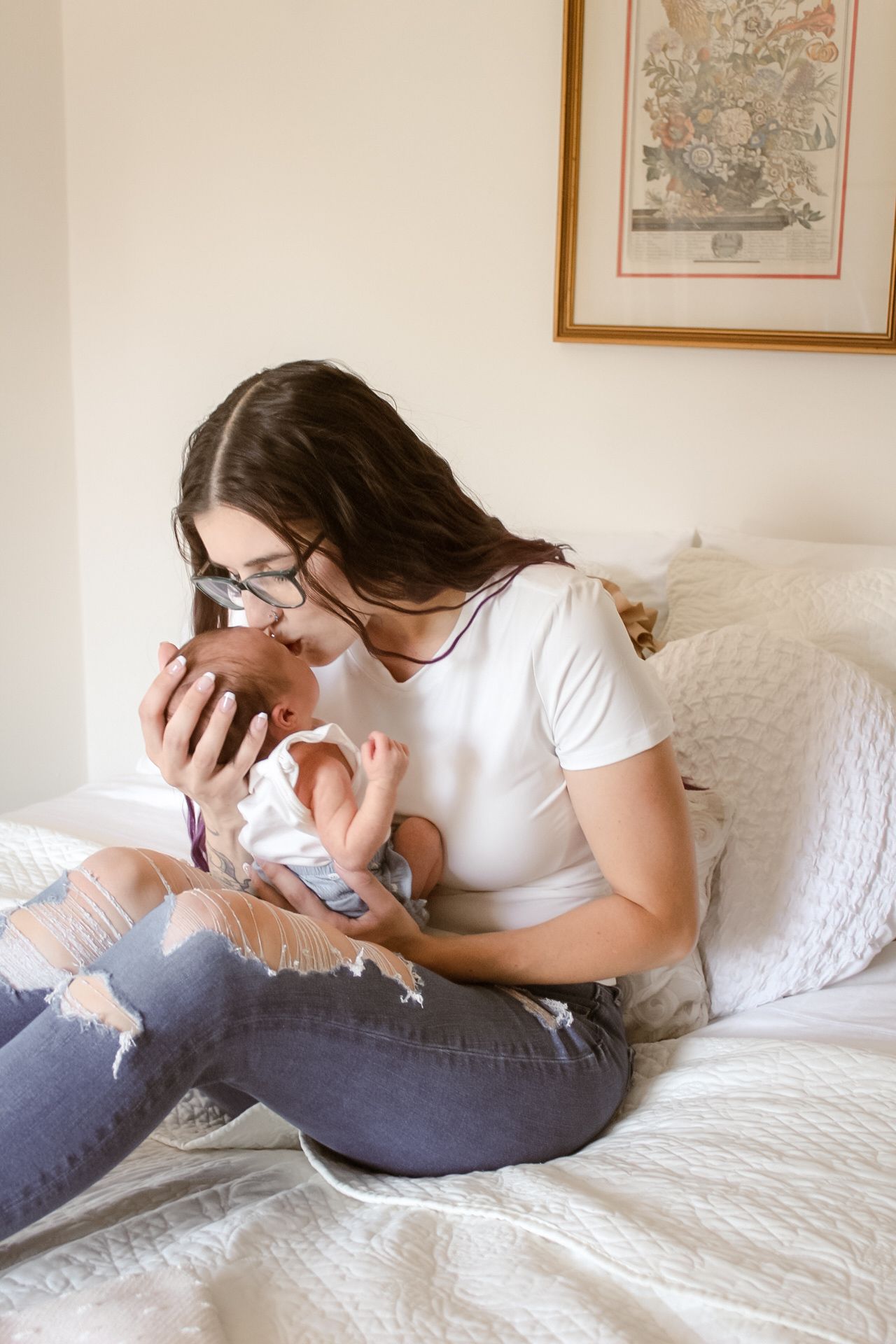 A heartwarming moment of snuggling and bonding on a white bed with decorative wall art visible in the background.