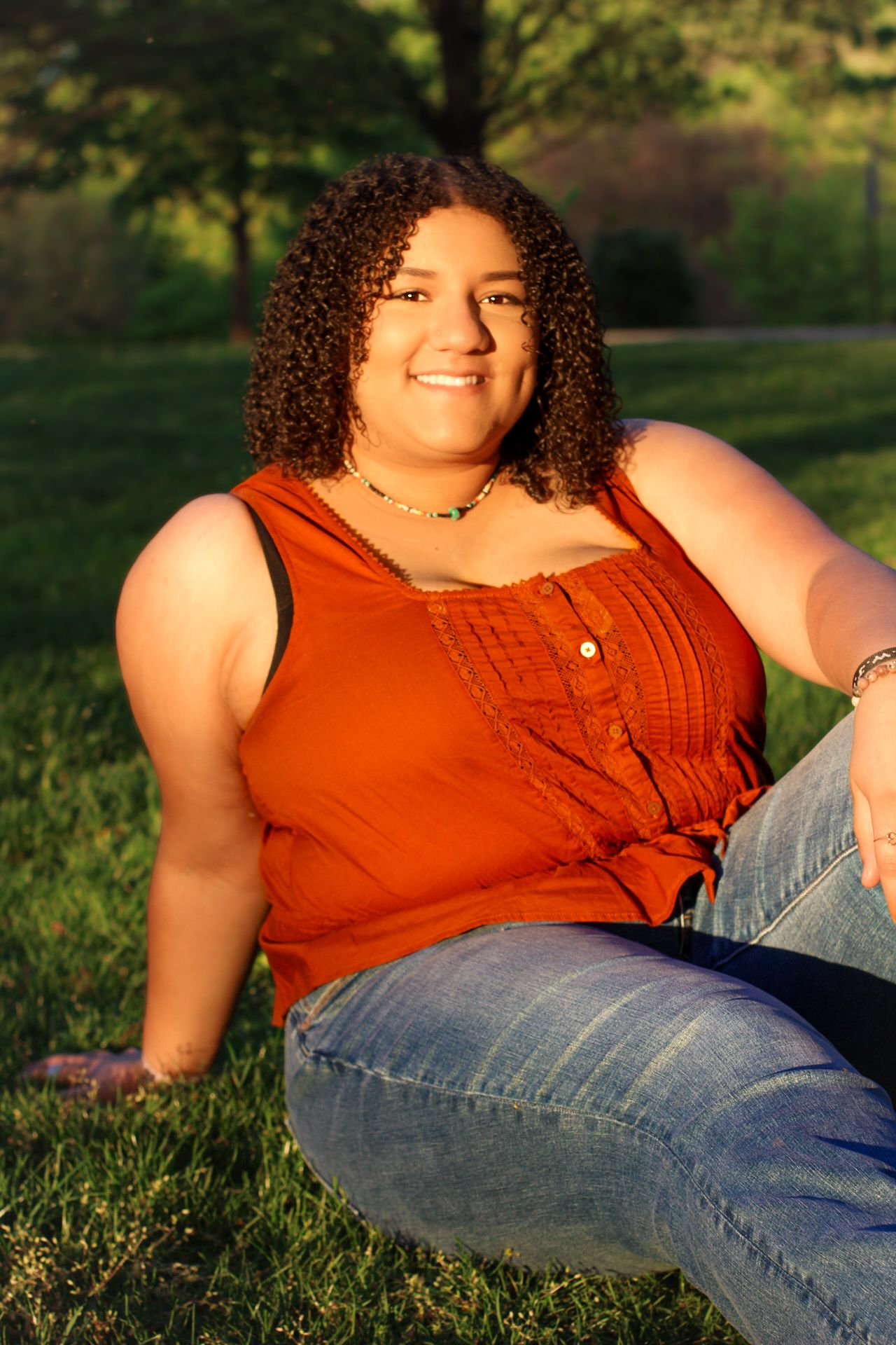 Casual outdoor portraits in golden sunlight wearing denim and rust-colored top.