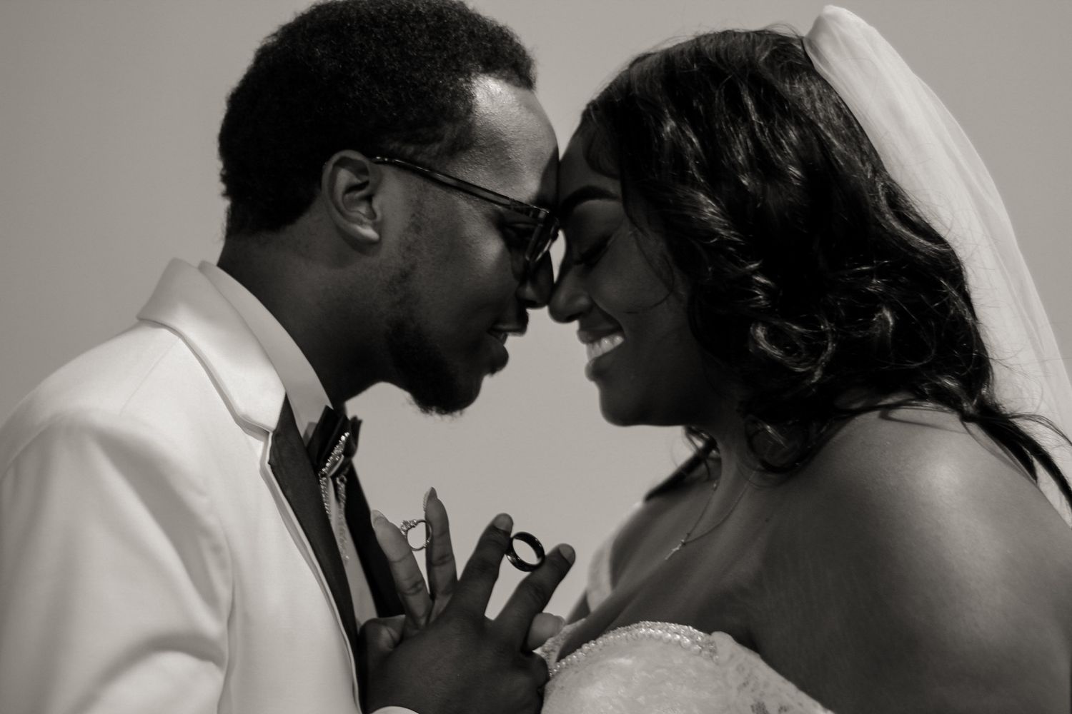 Black and white intimate portrait of newlyweds sharing a tender moment on their wedding day.
