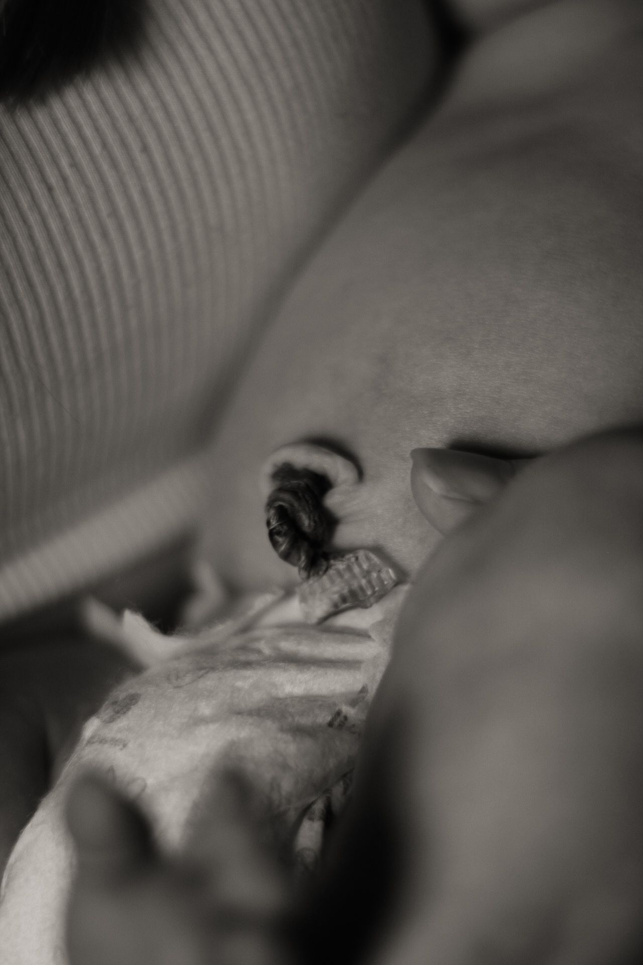 Artistic black and white close-up of a newborn's healing umbilical cord area.