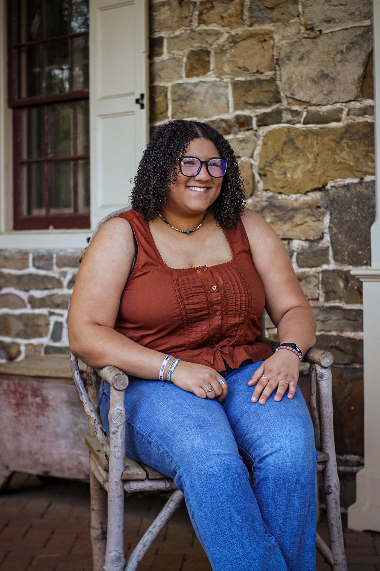 A relaxed portrait session on a rustic stone porch with wooden rocking chairs.