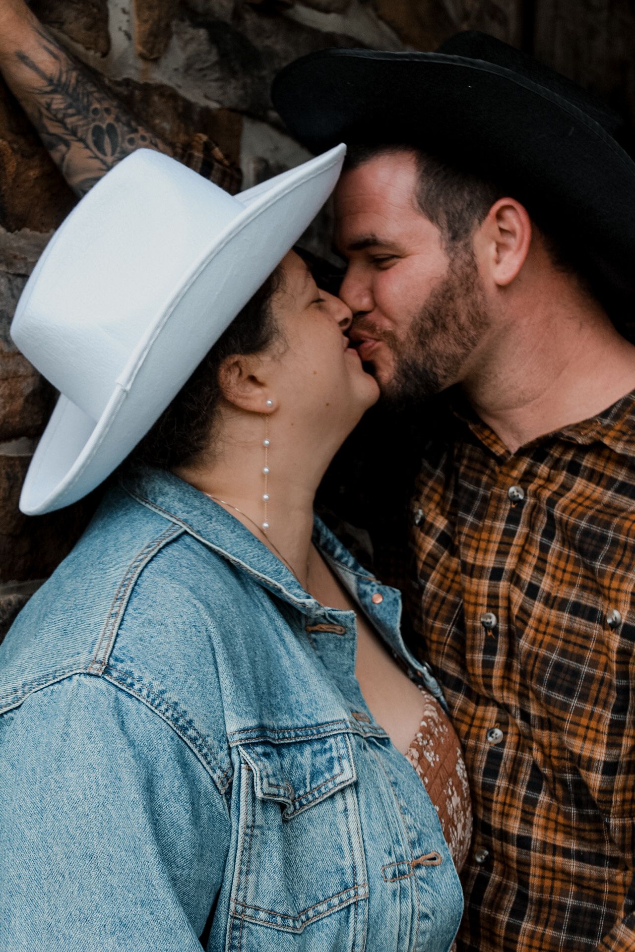 Close-up view of a couple wearing denim and plaid sharing a tender moment.