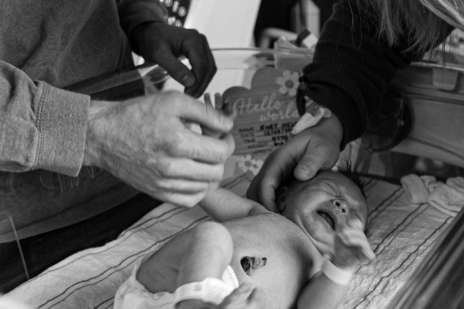 Medical staff examining and caring for a newborn baby in black and white.