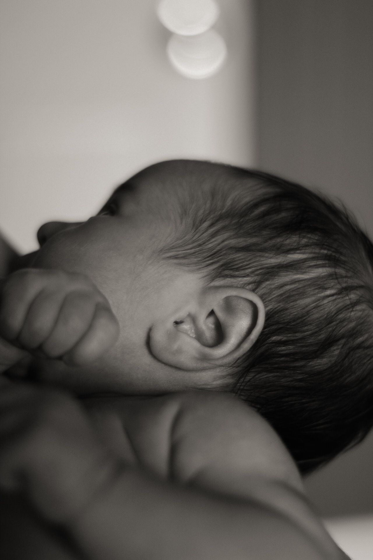 Side profile of a sleeping infant in black and white.