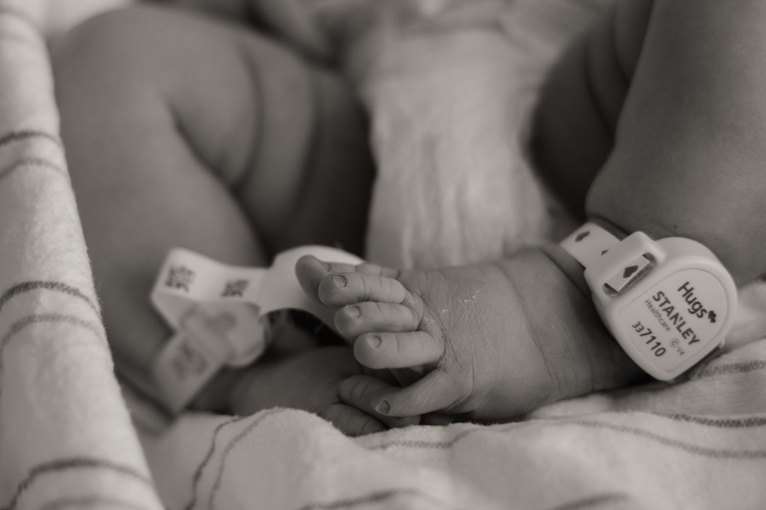 Close-up black and white image of newborn baby details.