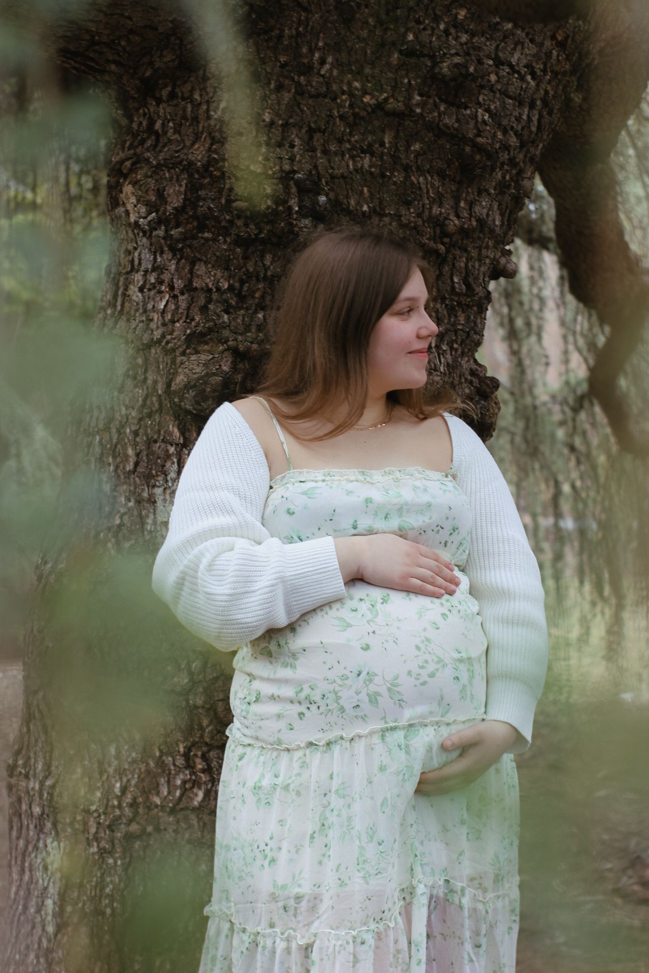 A romantic scene captured in a forest with soft natural lighting and moss-covered trees.