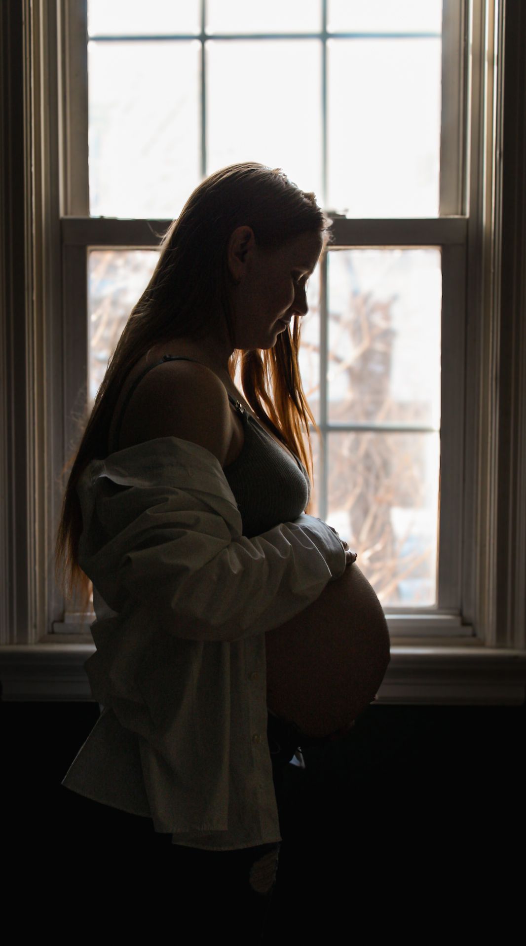 Silhouette by window showing expectant figure in gentle lighting.