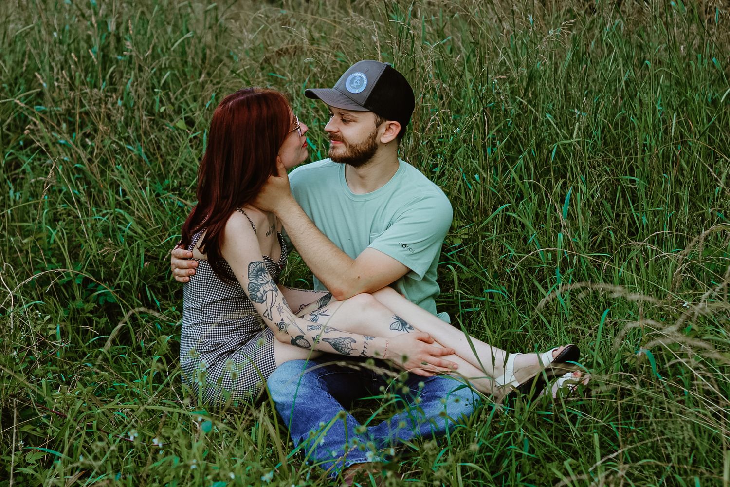 Couple relaxing together in green summer grass.