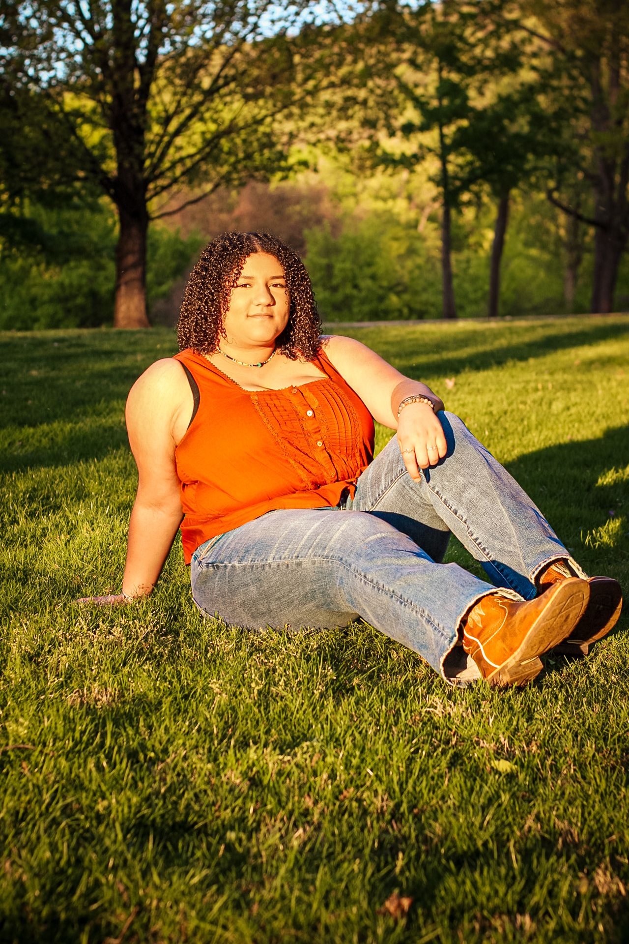 Laid-back portraits on sunlit grass wearing casual denim and orange attire.