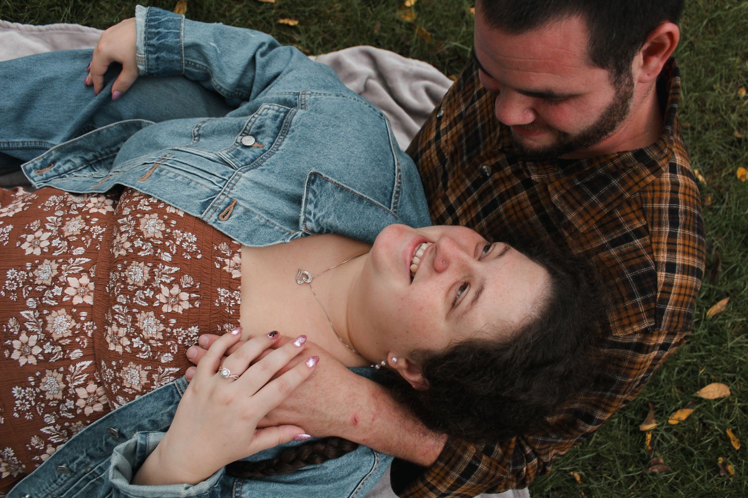 Romantic embrace captured in natural outdoor setting with autumn foliage.