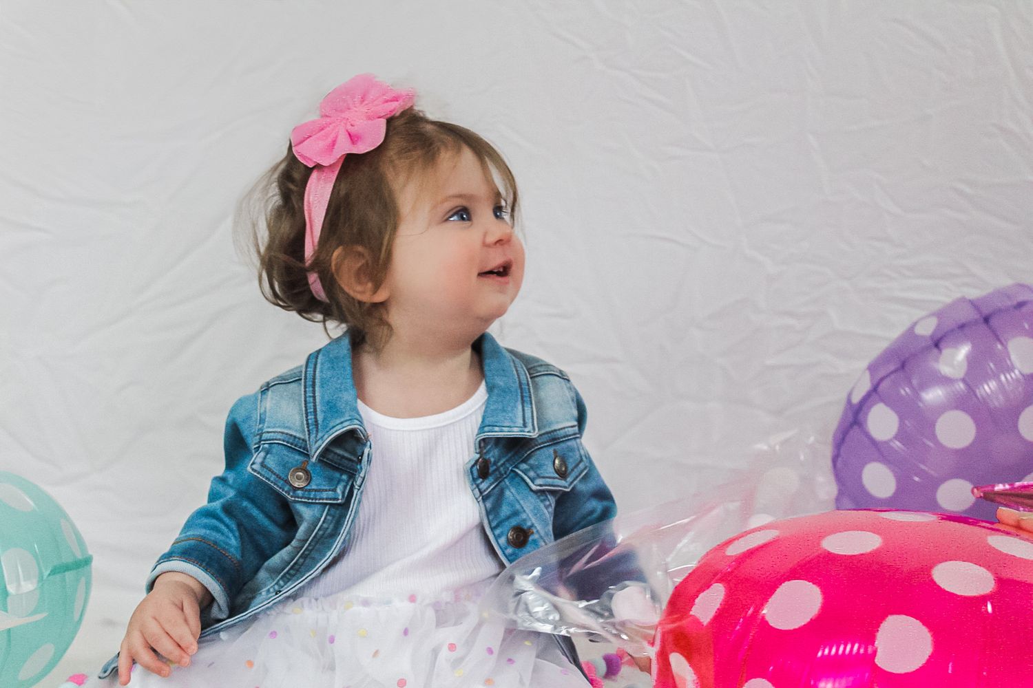 Birthday party scene with polka dot balloons and pink accessories.