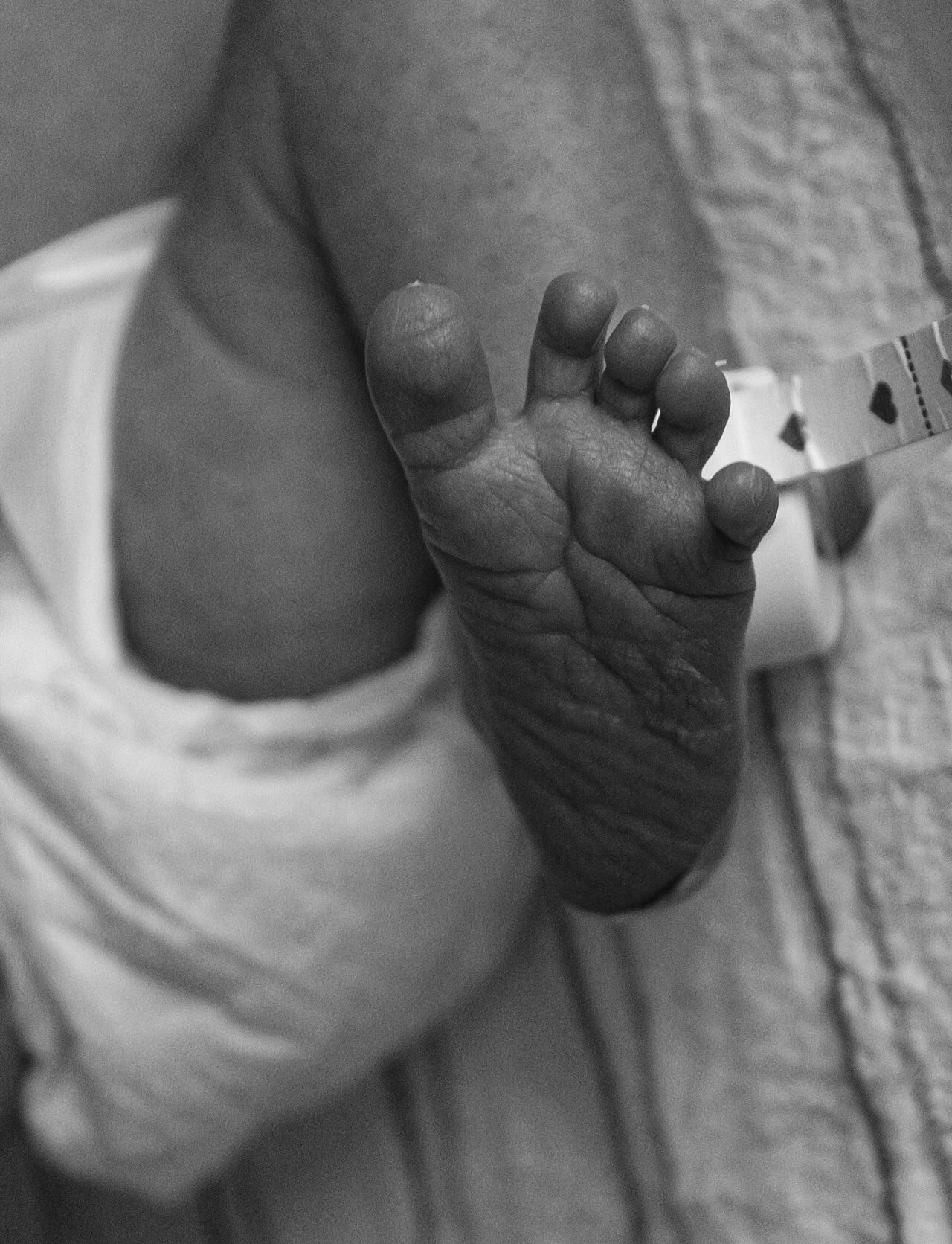 Detailed black and white image of a tiny infant's foot.