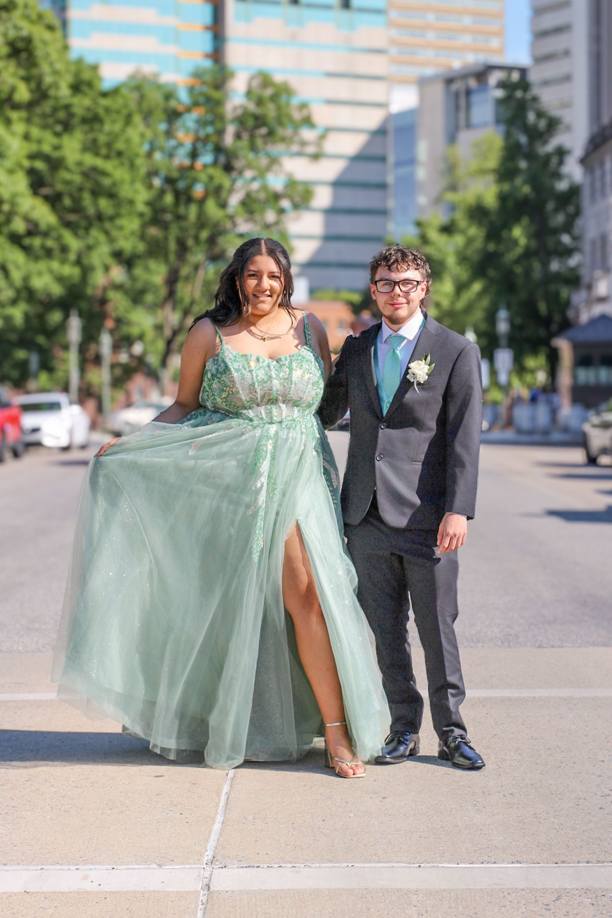 A playful outdoor portrait session featuring a mint green gown against an urban backdrop.