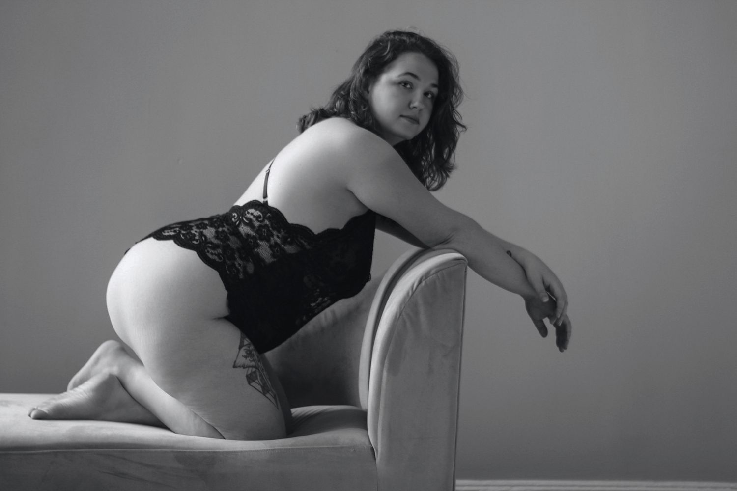 Intimate portrait on vintage furniture showing delicate black lace details.