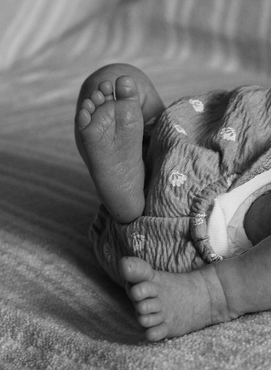 Black and white detail shots of baby feet wrapped in textured material.