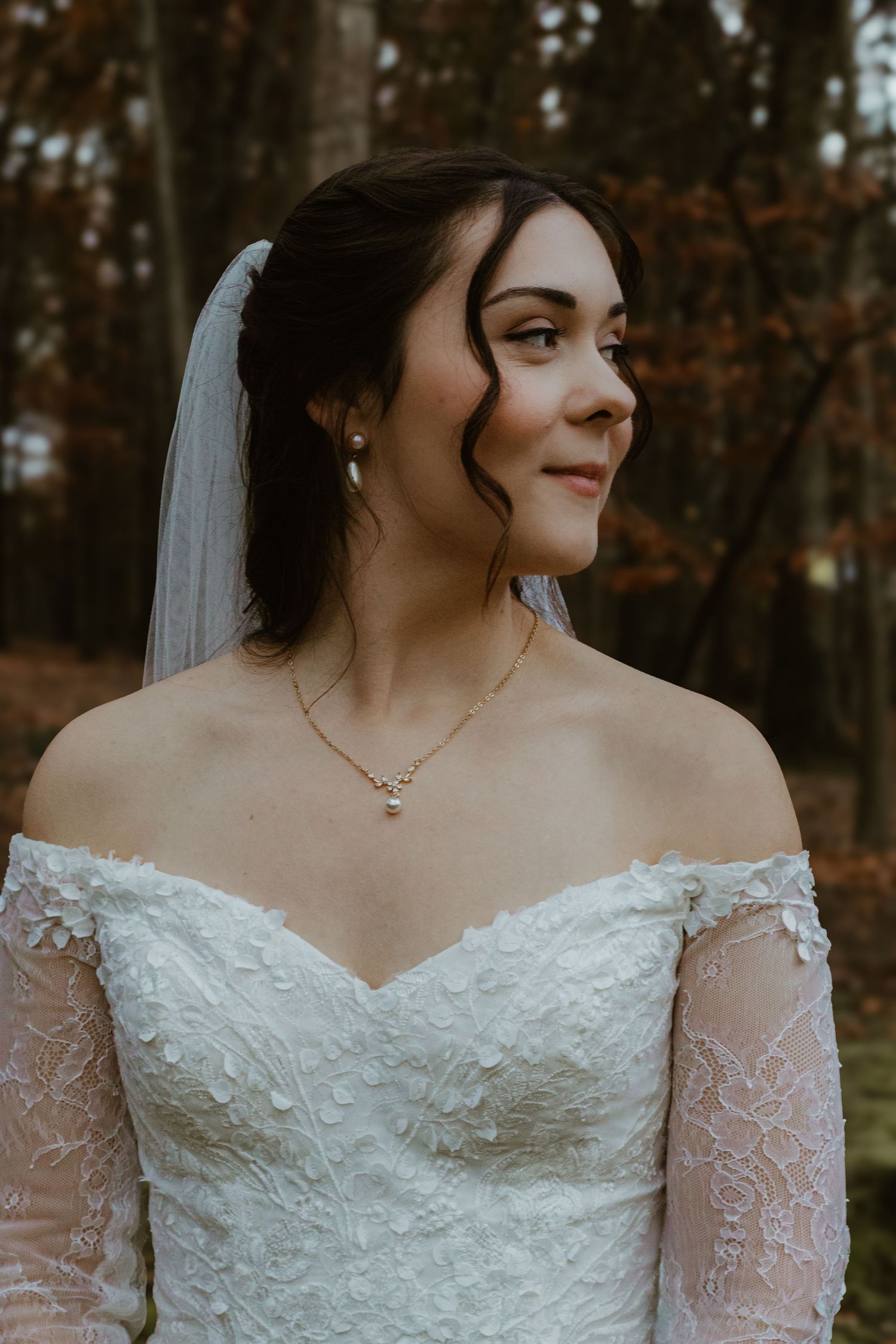 Close-up details of a lace wedding dress with off-shoulder neckline and delicate embellishments.