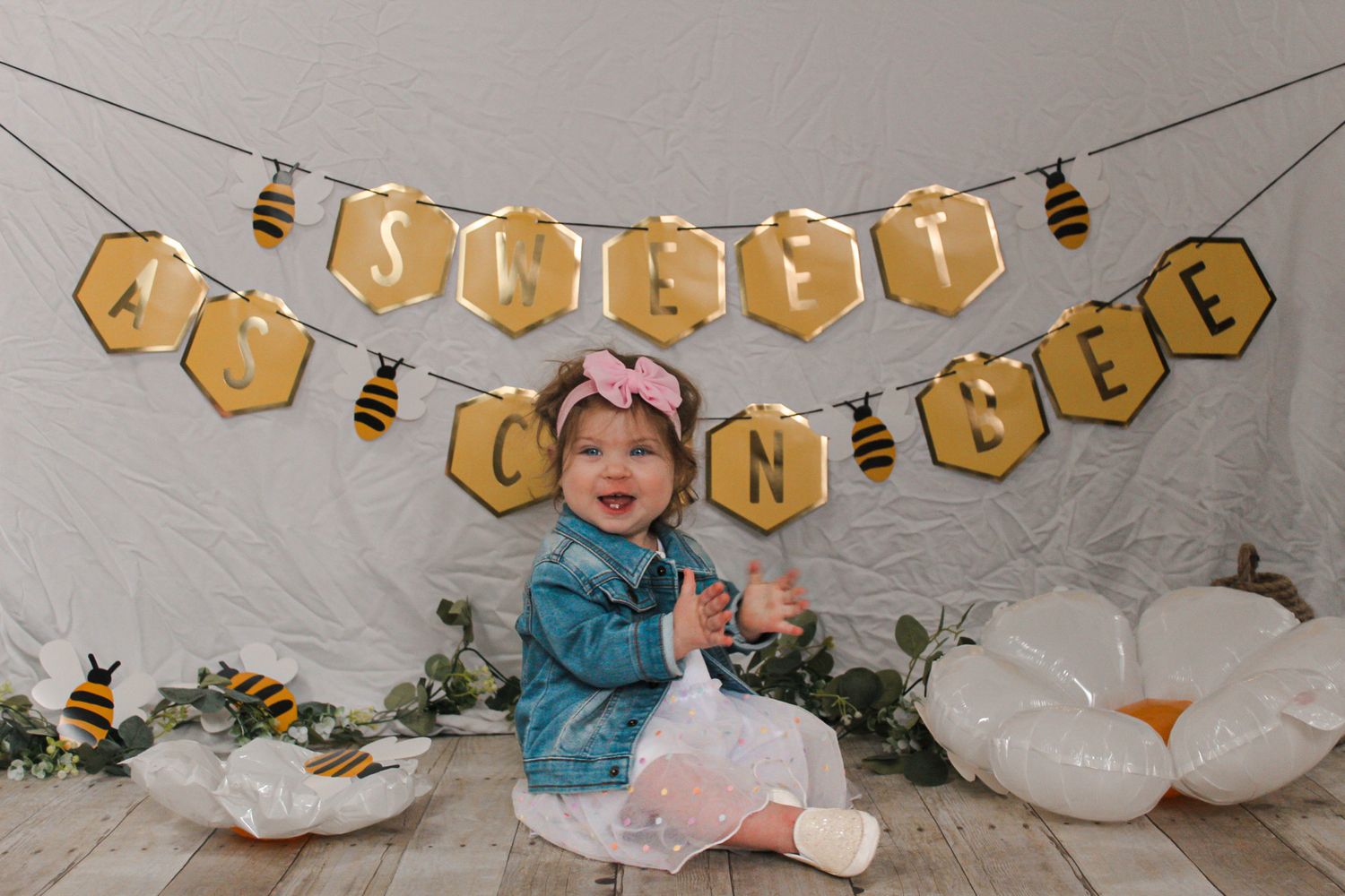 Yellow honeycomb banner with bee decorations hanging against a neutral wall.
