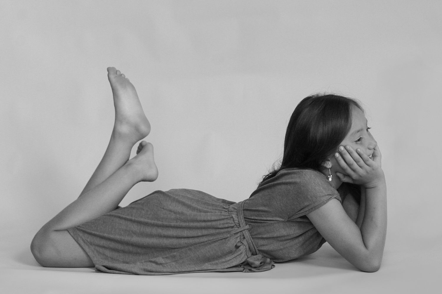 Artistic black and white portrait series showing relaxed poses on studio floor.