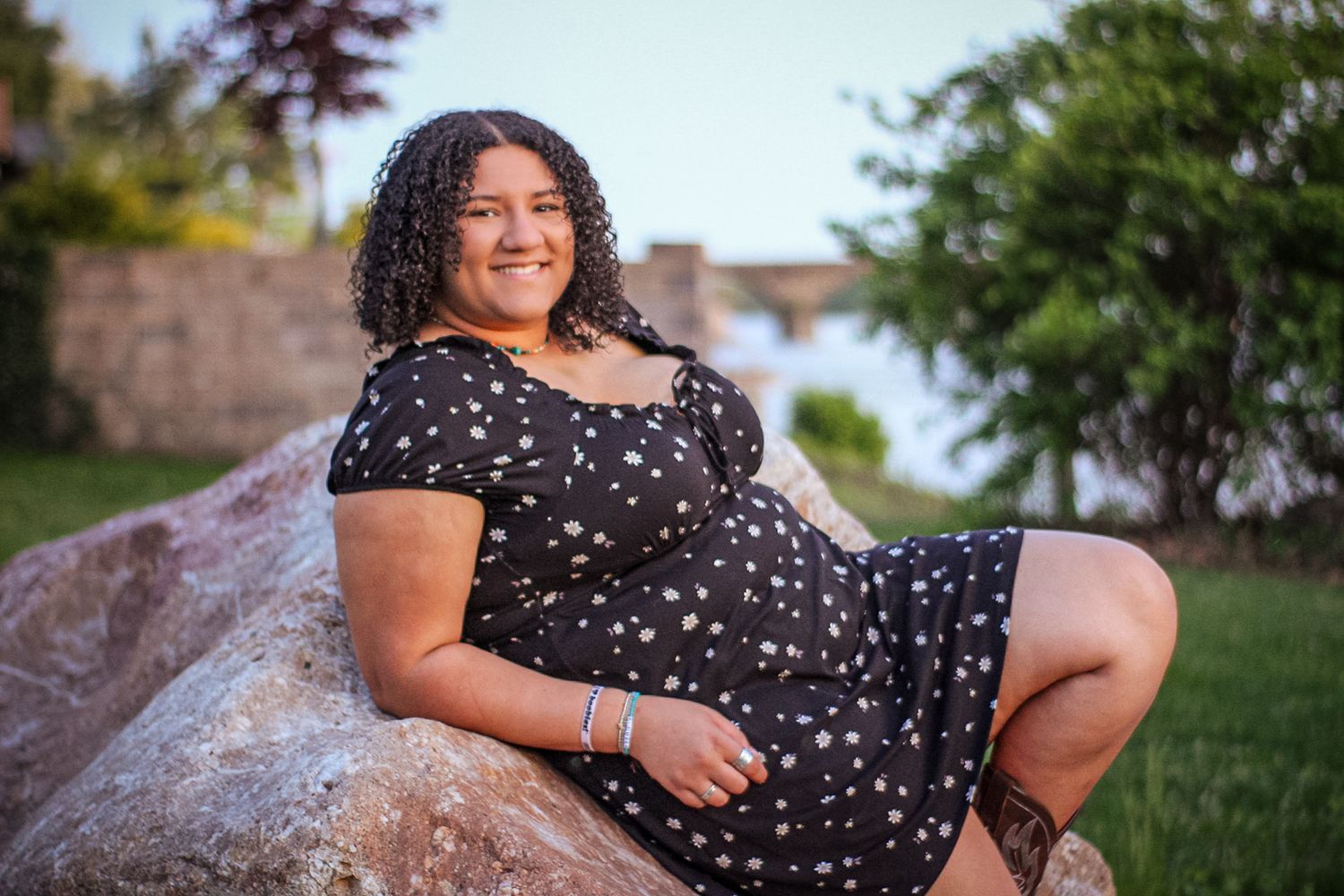 Relaxed outdoor portrait session on rocks in a floral print dress.