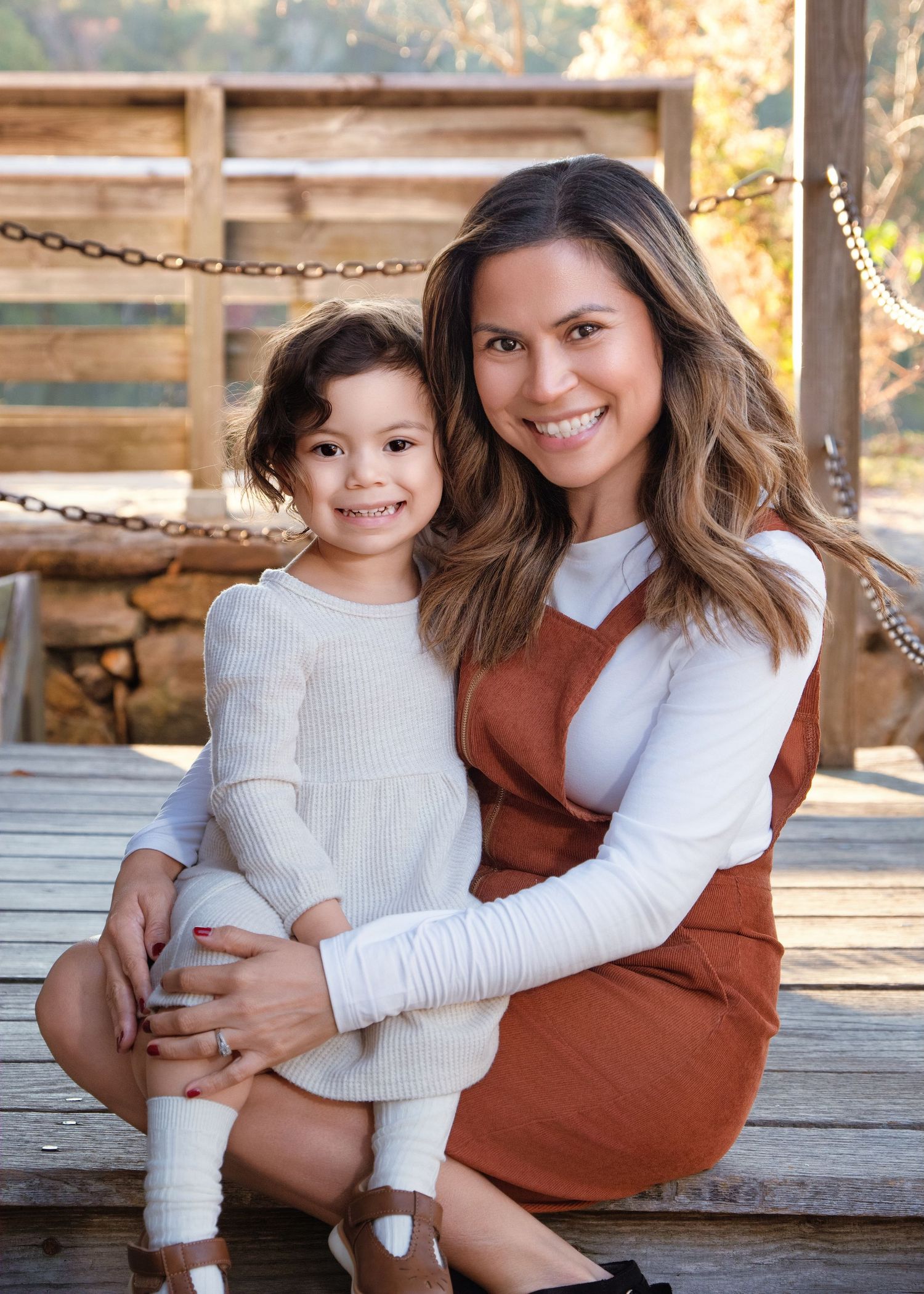 A heartwarming portrait on a wooden deck shows two people sharing a tender moment in matching white sweaters.