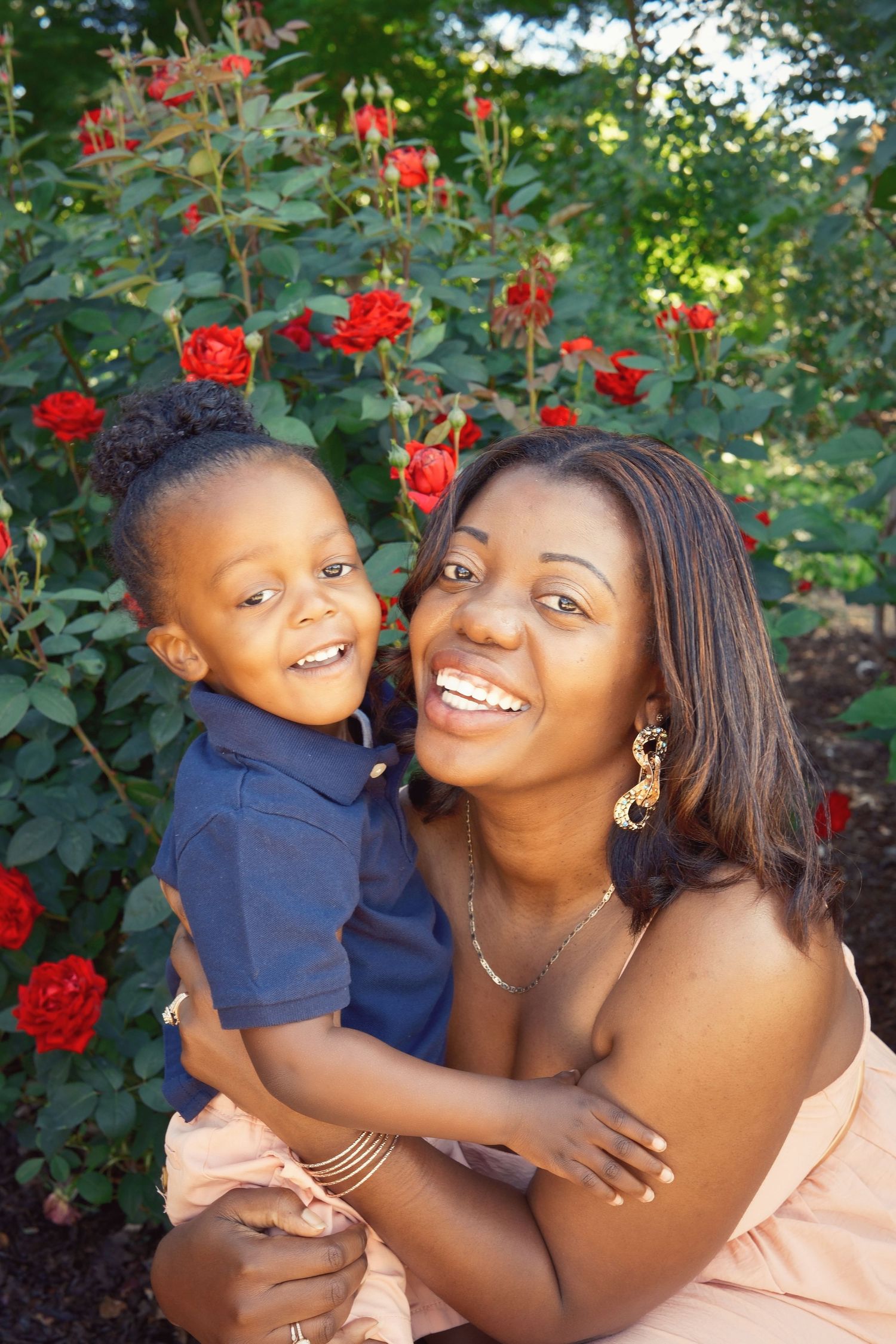 A heartwarming moment captured in a garden with blooming red roses.