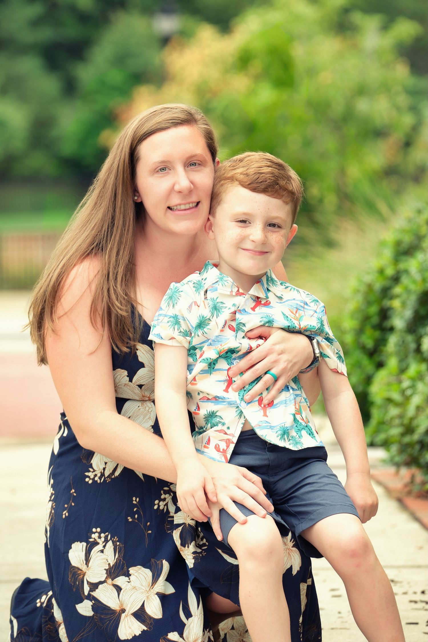 Summer portrait in a garden with floral dress and tropical print shirt.